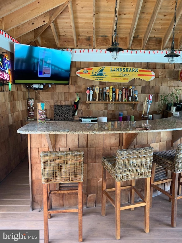 bar with beam ceiling, wooden ceiling, and hardwood / wood-style flooring