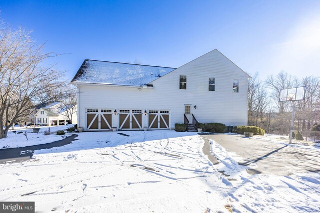 view of snow covered exterior with a garage