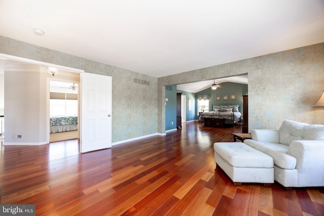 living room with hardwood / wood-style floors, ceiling fan, and vaulted ceiling