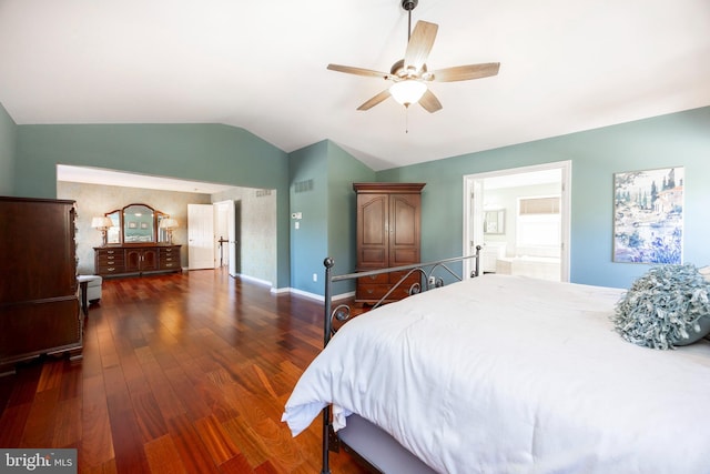 bedroom with dark hardwood / wood-style flooring, vaulted ceiling, ceiling fan, and connected bathroom