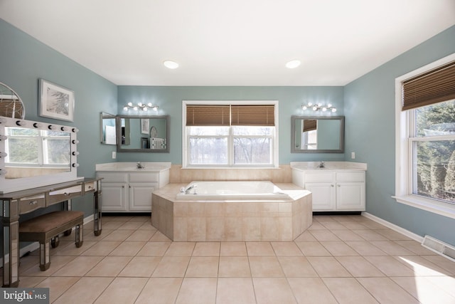 bathroom featuring vanity, tile patterned floors, and tiled tub