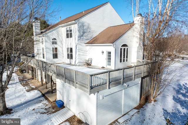 snow covered rear of property featuring a balcony