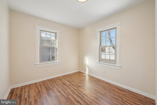 spare room with hardwood / wood-style floors and a healthy amount of sunlight