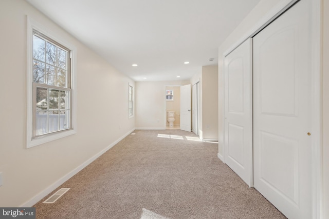 hall featuring light colored carpet