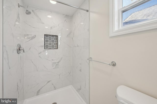 bathroom featuring toilet and a tile shower