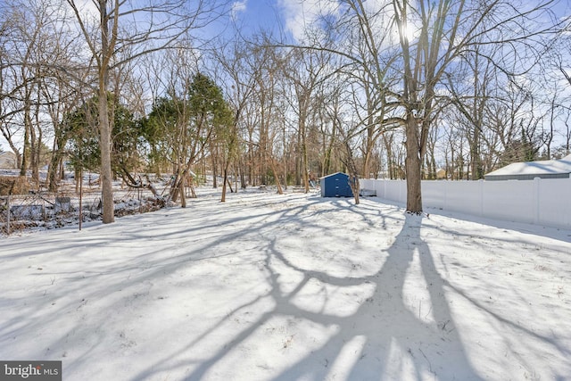 yard covered in snow featuring a shed