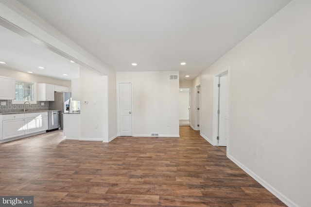 unfurnished living room with dark wood-type flooring and sink