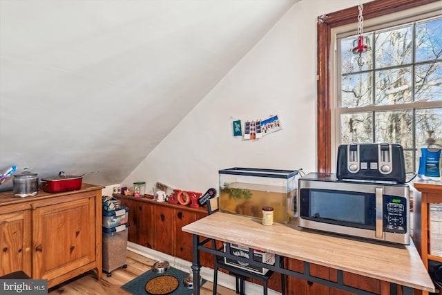 office with light hardwood / wood-style flooring and vaulted ceiling