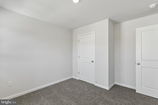 unfurnished bedroom featuring dark colored carpet