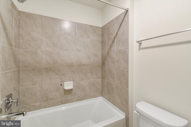 bathroom with toilet and tiled shower / bath