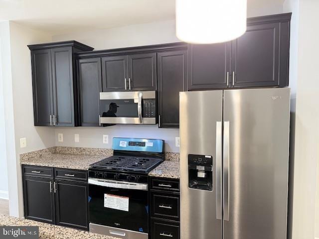 kitchen with light stone counters and appliances with stainless steel finishes