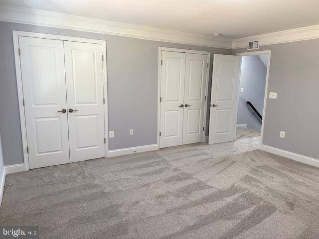 unfurnished bedroom featuring light carpet and ornamental molding