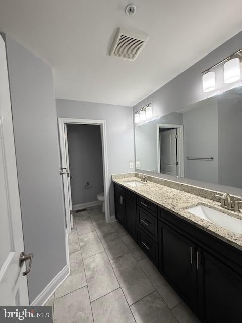 bathroom featuring tile patterned flooring, vanity, and toilet