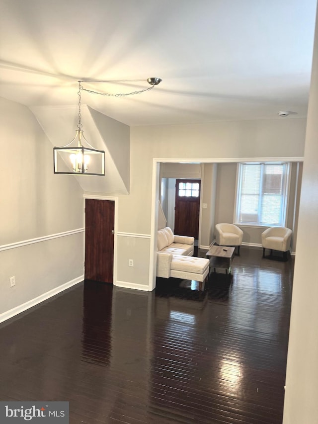 interior space featuring vaulted ceiling, dark hardwood / wood-style floors, and a chandelier