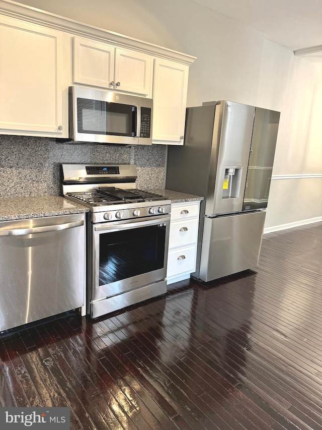 kitchen with appliances with stainless steel finishes, stone countertops, dark hardwood / wood-style floors, white cabinetry, and decorative backsplash