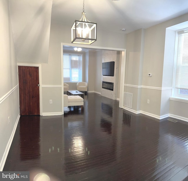 unfurnished living room with dark hardwood / wood-style flooring and a notable chandelier