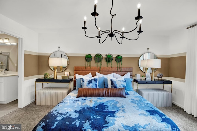 carpeted bedroom featuring connected bathroom and a chandelier