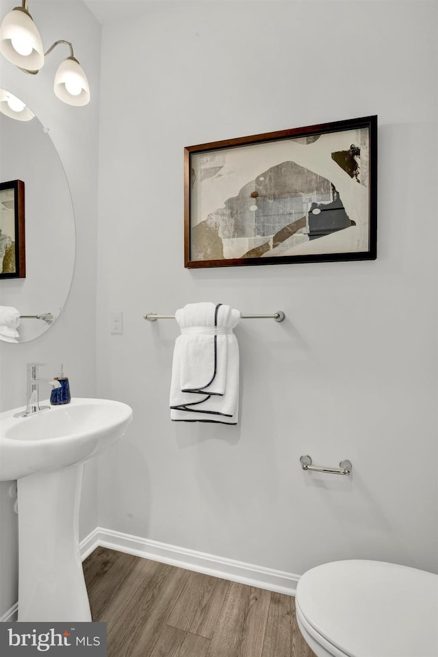 bathroom with hardwood / wood-style flooring and toilet