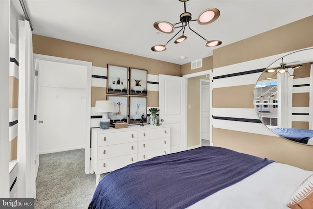 bedroom featuring a chandelier, a closet, light colored carpet, and a spacious closet