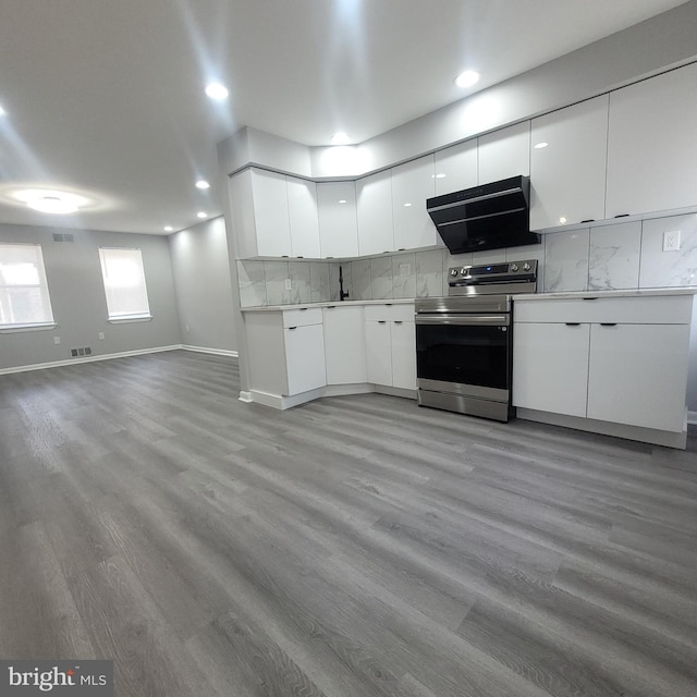 kitchen featuring white cabinetry, sink, light hardwood / wood-style flooring, backsplash, and stainless steel range with electric stovetop