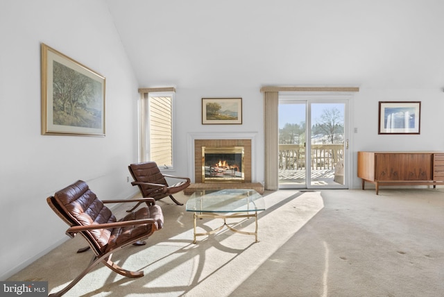 living area featuring lofted ceiling, a brick fireplace, and carpet