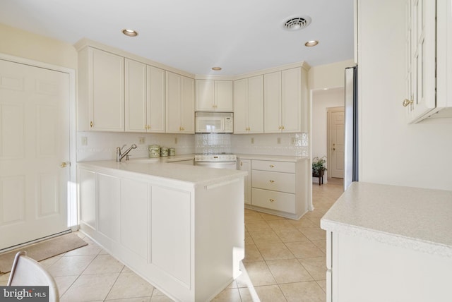 kitchen with backsplash, white appliances, kitchen peninsula, and light tile patterned floors