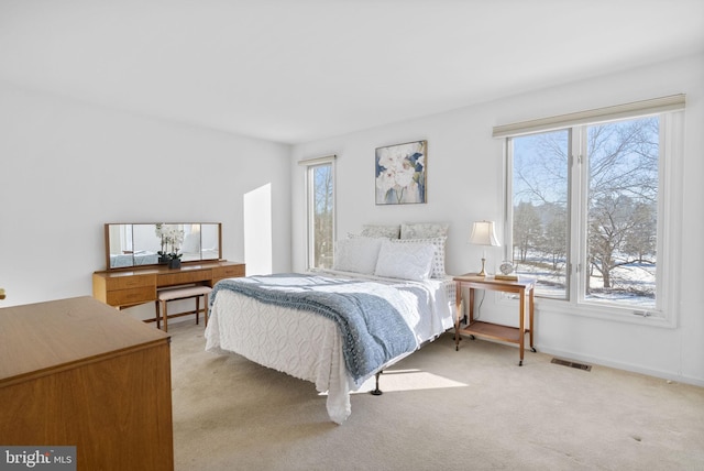 bedroom featuring multiple windows and light colored carpet