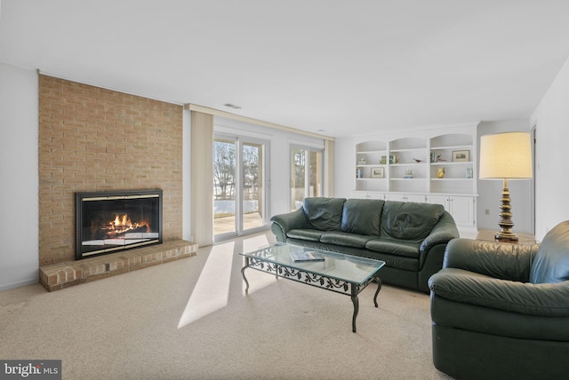 living room featuring a brick fireplace, light colored carpet, and built in shelves