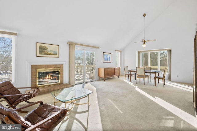 living room with light carpet, a brick fireplace, and high vaulted ceiling