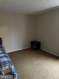 unfurnished bedroom with carpet floors and a textured ceiling