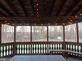 unfurnished sunroom with lofted ceiling with beams and wood ceiling