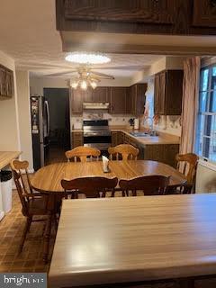 dining space with ceiling fan and sink