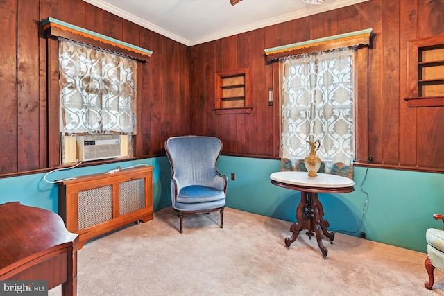 sitting room featuring radiator, ornamental molding, light colored carpet, cooling unit, and wooden walls