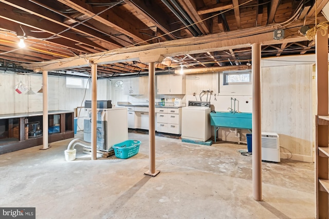 basement featuring washer and clothes dryer and sink