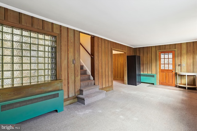 unfurnished living room featuring carpet flooring, radiator, and crown molding