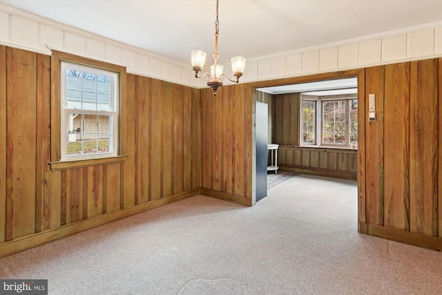 carpeted spare room featuring crown molding and a chandelier