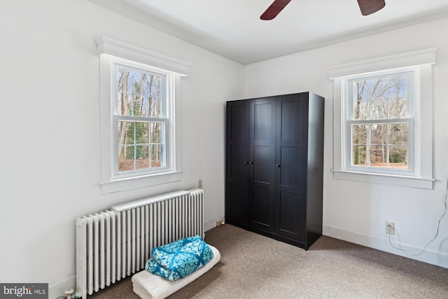 carpeted bedroom featuring radiator heating unit and ceiling fan