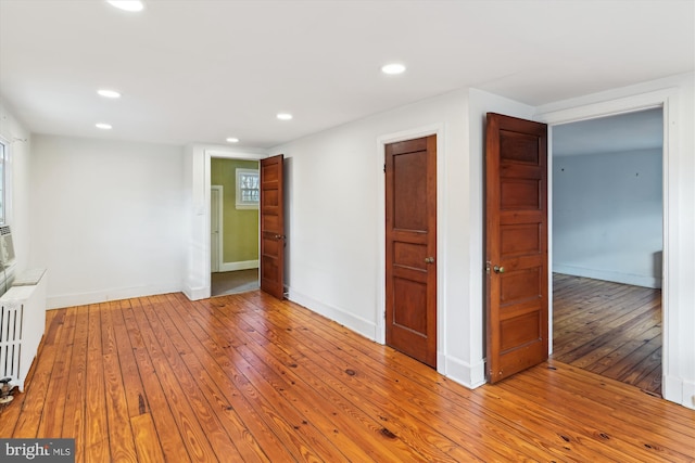 unfurnished room featuring radiator and light hardwood / wood-style floors