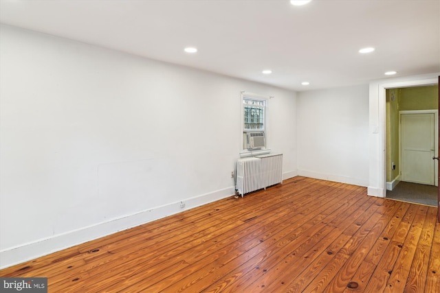 empty room featuring radiator heating unit and hardwood / wood-style floors