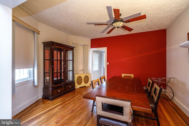 dining area featuring ceiling fan, light hardwood / wood-style floors, and a textured ceiling