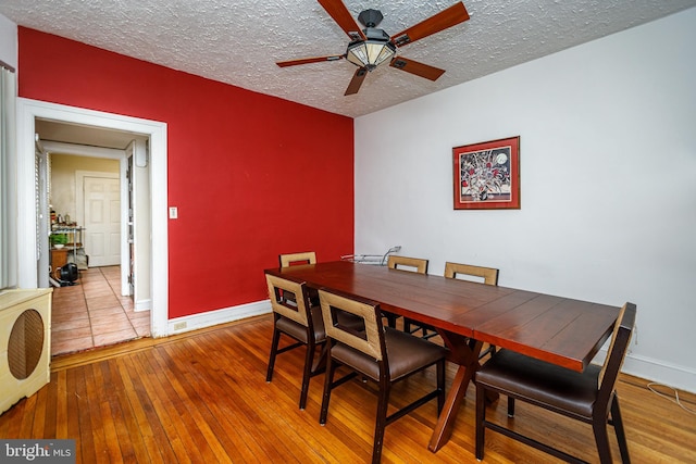 dining area with ceiling fan, a textured ceiling, and light wood-type flooring