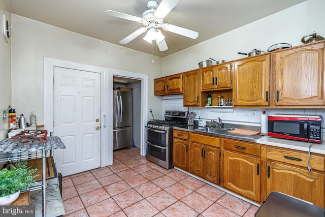 kitchen featuring sink, light tile patterned floors, ceiling fan, stainless steel appliances, and backsplash