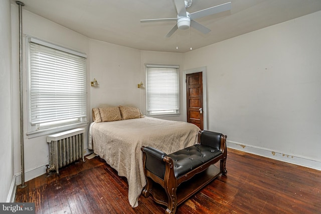 bedroom featuring dark hardwood / wood-style flooring, radiator, and ceiling fan