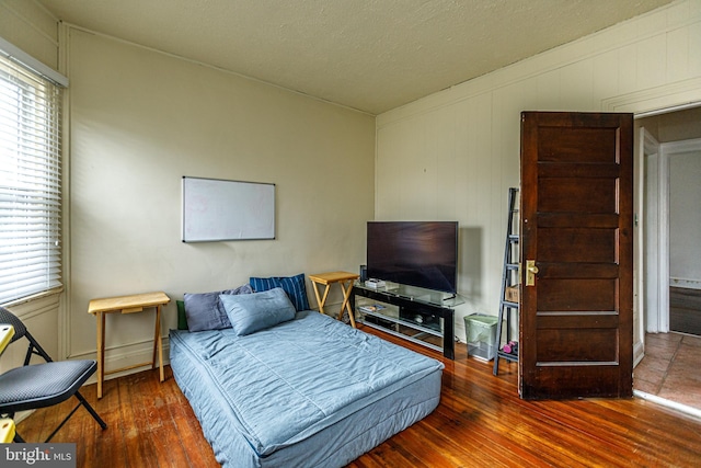 bedroom with multiple windows and hardwood / wood-style floors