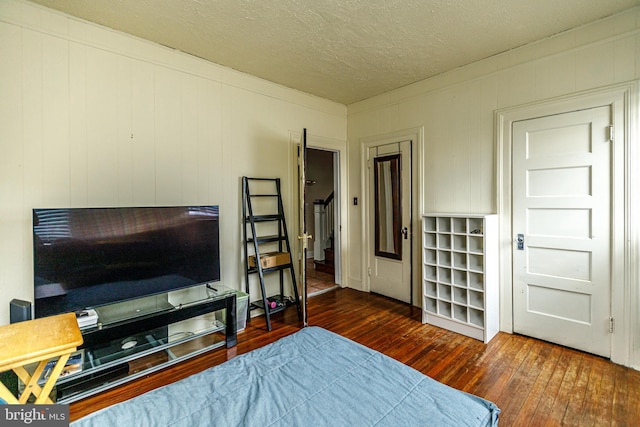 bedroom with dark wood-type flooring and a textured ceiling