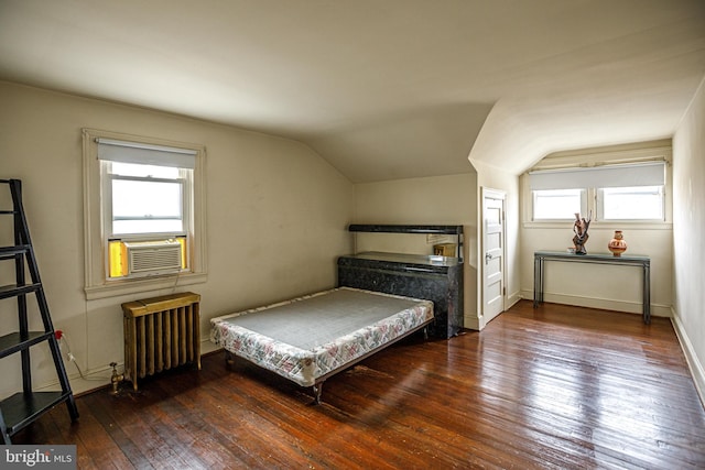 bedroom with vaulted ceiling, radiator, and dark wood-type flooring