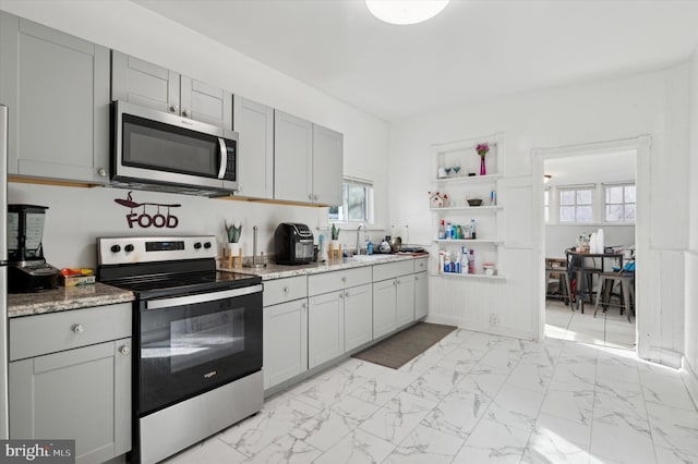 kitchen with gray cabinets, light stone countertops, sink, and appliances with stainless steel finishes