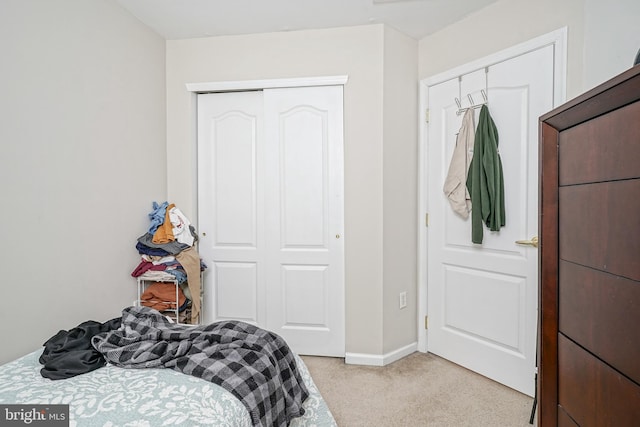 bedroom featuring light carpet and a closet