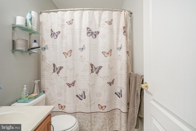 bathroom with vanity, curtained shower, and toilet