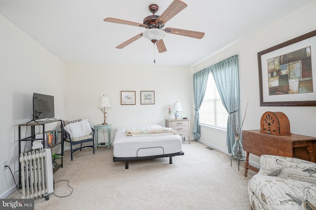 bedroom with ceiling fan, light colored carpet, and radiator